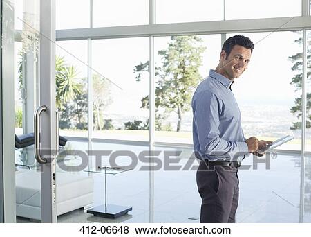 Businessman using tablet computer in office View Large Photo Image Stock Photo - Businessman using tablet computer in office. Fotosearch