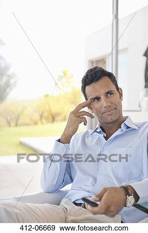 Businessman watching television in office View Large Photo Image Stock Photo - Businessman watching television in office. Fotosearch