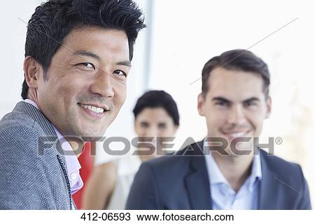 Businessmen smiling in office View Large Photo Image Stock Image - Businessmen smiling in office. Fotosearch