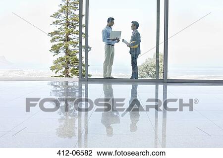 Businessmen talking in office View Large Photo Image Stock Image - Businessmen talking in office. Fotosearch