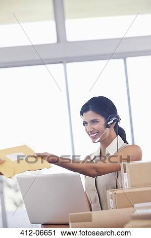 Businesswoman accepting packages in office View Large Photo Image Stock Image - Businesswoman accepting packages in office. Fotosearch
