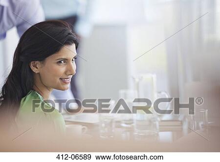 Businesswoman smiling at meeting table View Large Photo Image Stock Photo - Businesswoman smiling at meeting table. Fotosearch