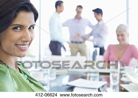 Picture - Businesswoman smiling in meeting. Fotosearch