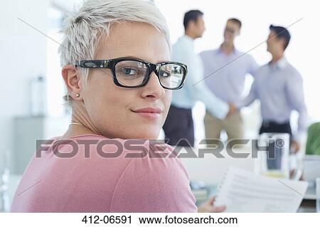 Stock Image - Businesswoman smiling in office. Fotosearch