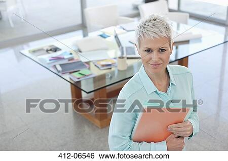 Businesswoman smiling in office View Large Photo Image Stock Photograph - Businesswoman smiling in office. Fotosearch