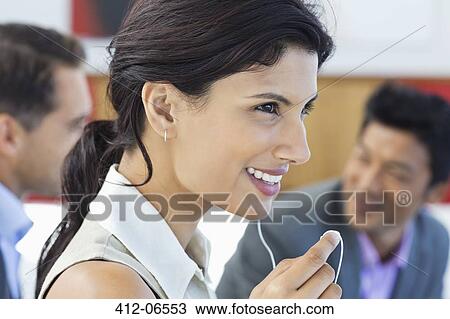 Businesswoman talking on headset in office View Large Photo Image Stock Image - Businesswoman talking on headset in office. Fotosearch