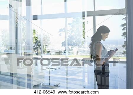 Businesswoman using cell phone in office View Large Photo Image Stock Photo - Businesswoman using cell phone in office. Fotosearch