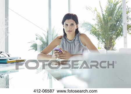 Businesswoman using cell phone in office View Large Photo Image Stock Photo - Businesswoman using cell phone in office. Fotosearch