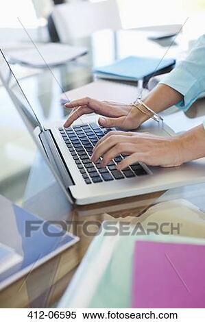 Businesswoman using laptop at desk View Large Photo Image Stock Photography - Businesswoman using laptop at desk. Fotosearch