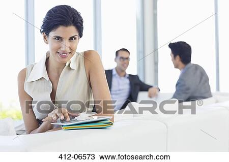 Stock Image - Businesswoman using tablet computer in office. Fotosearch