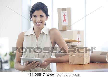 Businesswoman using tablet computer in office View Large Photo Image Stock Photo - Businesswoman using tablet computer in office. Fotosearch