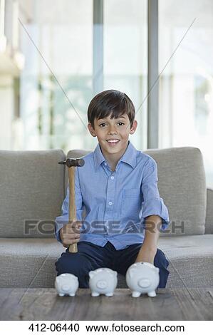 Boy holding hammer to smash piggy banks View Large Photo Image Stock Image - Boy holding hammer to smash piggy banks. Fotosearch