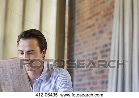 Businessman reading newspaper indoors View Large Photo Image Stock Photography - Businessman reading newspaper indoors. Fotosearch
