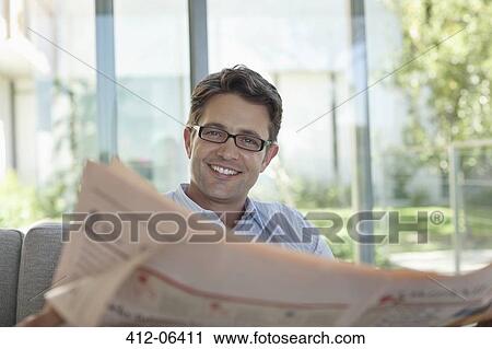 Businessman reading newspaper on sofa View Large Photo Image Stock Image - Businessman reading newspaper on sofa. Fotosearch