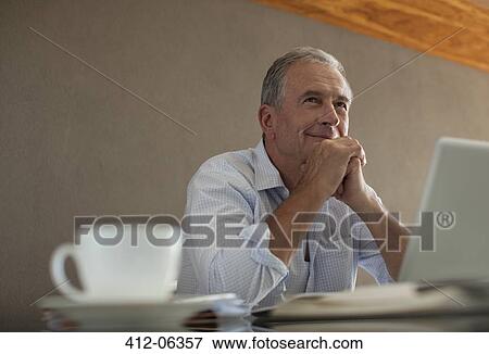 Stock Photo - Businessman sitting at desk. Fotosearch