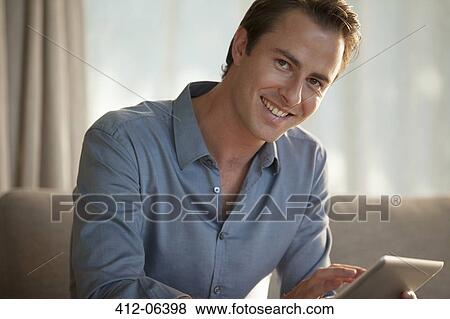 Businessman smiling on sofa View Large Photo Image Stock Photo - Businessman smiling on sofa. Fotosearch
