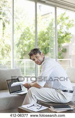 Businessman using laptop on sofa View Large Photo Image Stock Photo - Businessman using laptop on sofa. Fotosearch