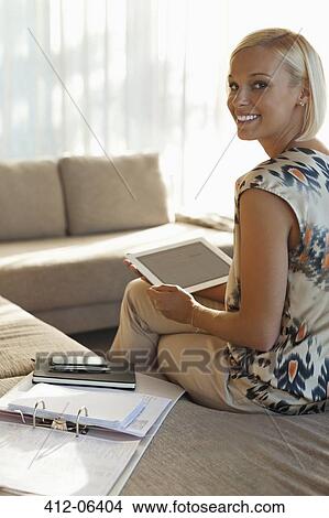 Businesswoman using tablet computer on sofa View Large Photo Image Picture - Businesswoman using tablet computer on sofa. Fotosearch