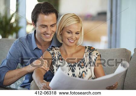 Couple examining blueprints together on sofa View Large Photo Image Stock Photo - Couple examining blueprints together on sofa. Fotosearch