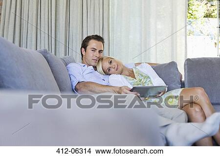 Couple relaxing on sofa together View Large Photo Image Picture - Couple relaxing on sofa together. Fotosearch