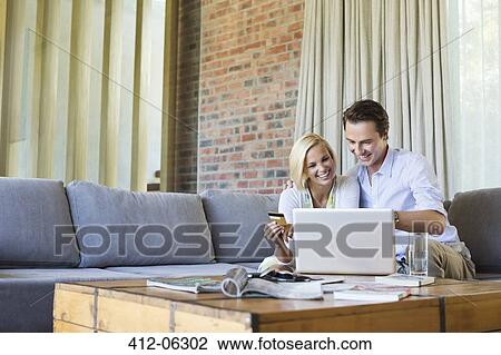 Couple shopping online on sofa View Large Photo Image Stock Image - Couple shopping online on sofa. Fotosearch