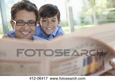 Stock Photo - Father and son reading newspaper together. Fotosearch