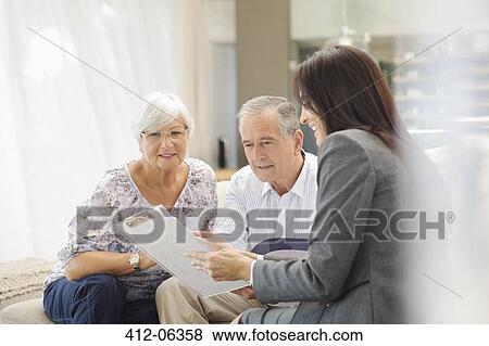 Financial advisor talking to couple on sofa View Large Photo Image Stock Photo - Financial advisor talking to couple on sofa. Fotosearch