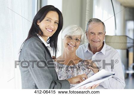 Financial advisor talking to couple indoors View Large Photo Image Stock Photography - Financial advisor talking to couple indoors. Fotosearch