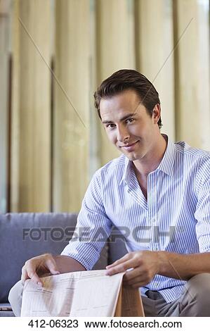 Man holding newspaper on sofa View Large Photo Image Stock Image - Man holding newspaper on sofa. Fotosearch