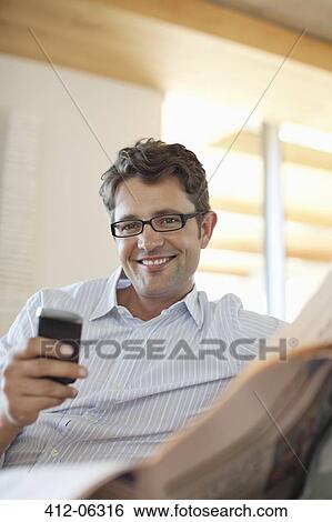 Man using cell phone on sofa View Large Photo Image Stock Photograph - Man using cell phone on sofa. Fotosearch