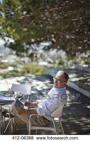 Stock Photo - Man using tablet computer outdoors. Fotosearch
