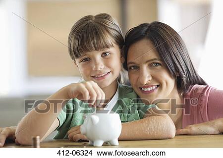 Mother and daughter filling piggy bank View Large Photo Image Picture - Mother and daughter filling piggy bank. Fotosearch