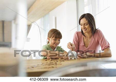 Mother and daughter filling piggy bank View Large Photo Image Stock Photo - Mother and daughter filling piggy bank. Fotosearch