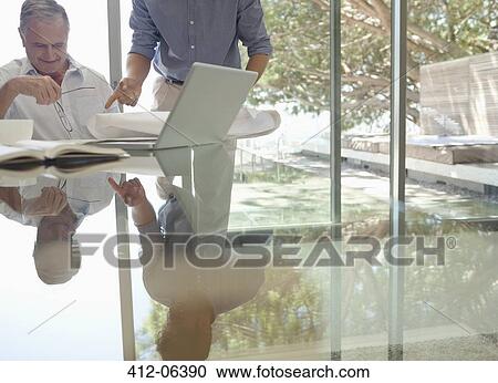 Older man and younger man talking at desk View Large Photo Image Stock Image - Older man and younger man talking at desk. Fotosearch