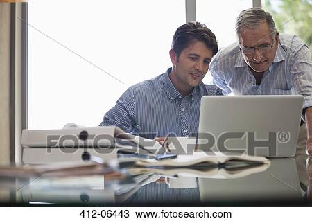 Older man and younger man working together at desk View Large Photo Image Stock Image - Older man and younger man working together at desk. Fotosearch
