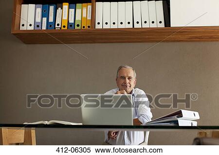 Stock Photography - Older man sitting at desk. Fotosearch