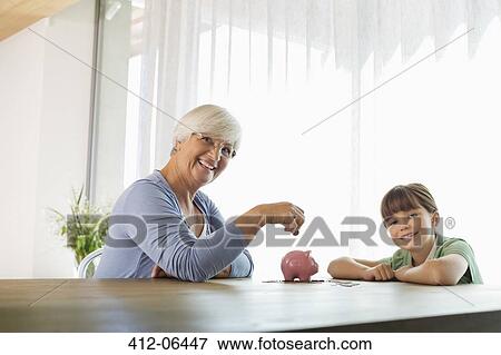 Older woman and granddaughter filling piggy bank View Large Photo Image Stock Photo - Older woman and granddaughter filling piggy bank. Fotosearch