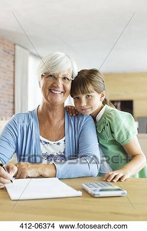 Older woman and granddaughter using calculator View Large Photo Image Picture - Older woman and granddaughter using calculator. Fotosearch