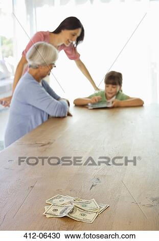 Stock Image - Three generations of women counting money. Fotosearch