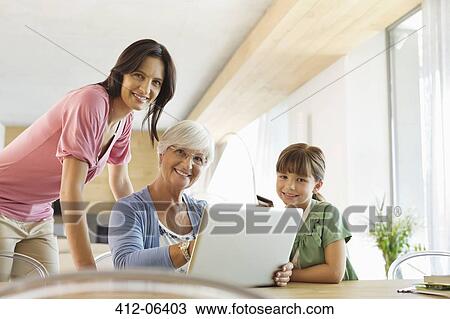 Three generations of women using laptop together View Large Photo Image Stock Image - Three generations of women using laptop together. Fotosearch
