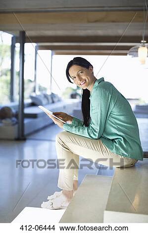 Picture - Woman using tablet computer on steps. Fotosearch