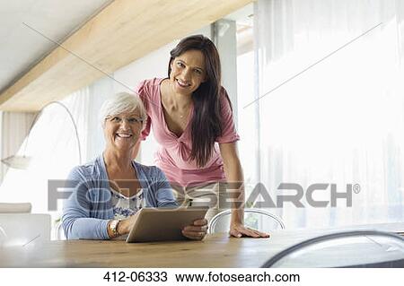 Women using tablet computer at table View Large Photo Image Stock Image - Women using tablet computer at table. Fotosearch