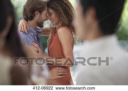 Stock Image - Couple hugging at party. Fotosearch