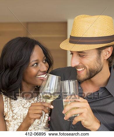 Stock Photography - Couple toasting each other indoors. Fotosearch