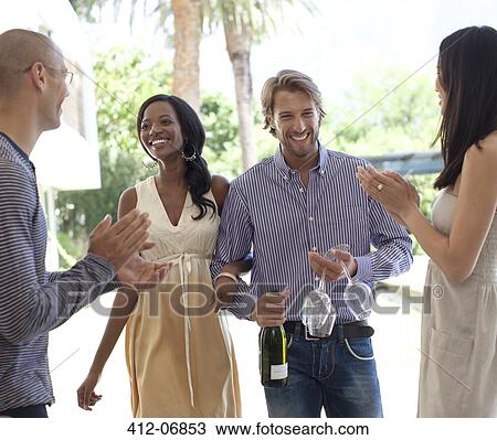 Friends cheering smiling couple View Large Photo Image Stock Image - Friends cheering smiling couple. Fotosearch