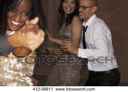 Stock Image - Friends dancing at party. Fotosearch