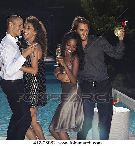 Friends dancing by swimming pool at party View Large Photo Image Stock Image - Friends dancing by swimming pool at party. Fotosearch