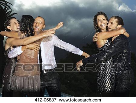 Stock Photo - Friends hugging at party. Fotosearch