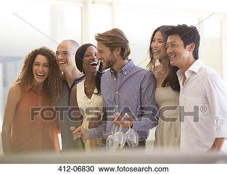 Friends laughing together at party View Large Photo Image Stock Image - Friends laughing together at party. Fotosearch