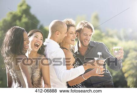 Friends laughing together at party View Large Photo Image Stock Photo - Friends laughing together at party. Fotosearch